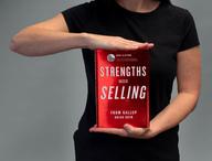 Person holding Strengths Based Selling.