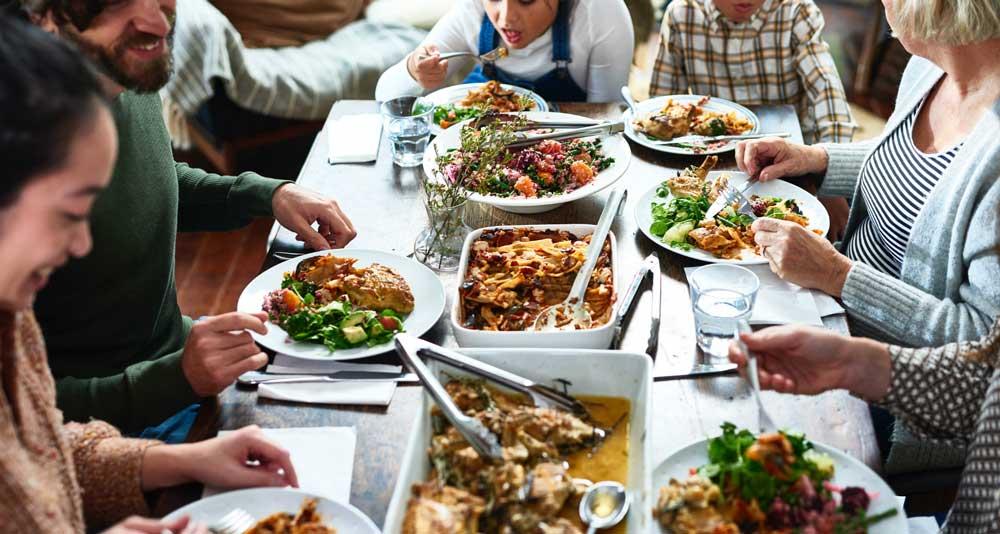 Descriptive image of people eating around a table. 