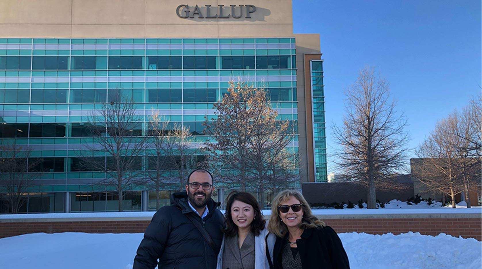 Three employees out in front of the Omaha office in the winter time.