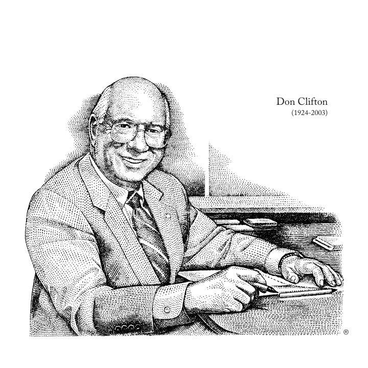 Don CLifton smiling sitting at a desk