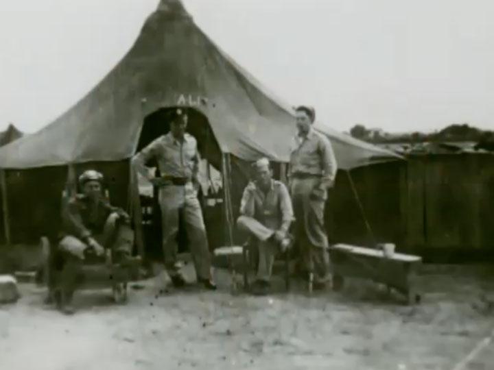 Don Clifton standing outside of a tent while serving in World War II