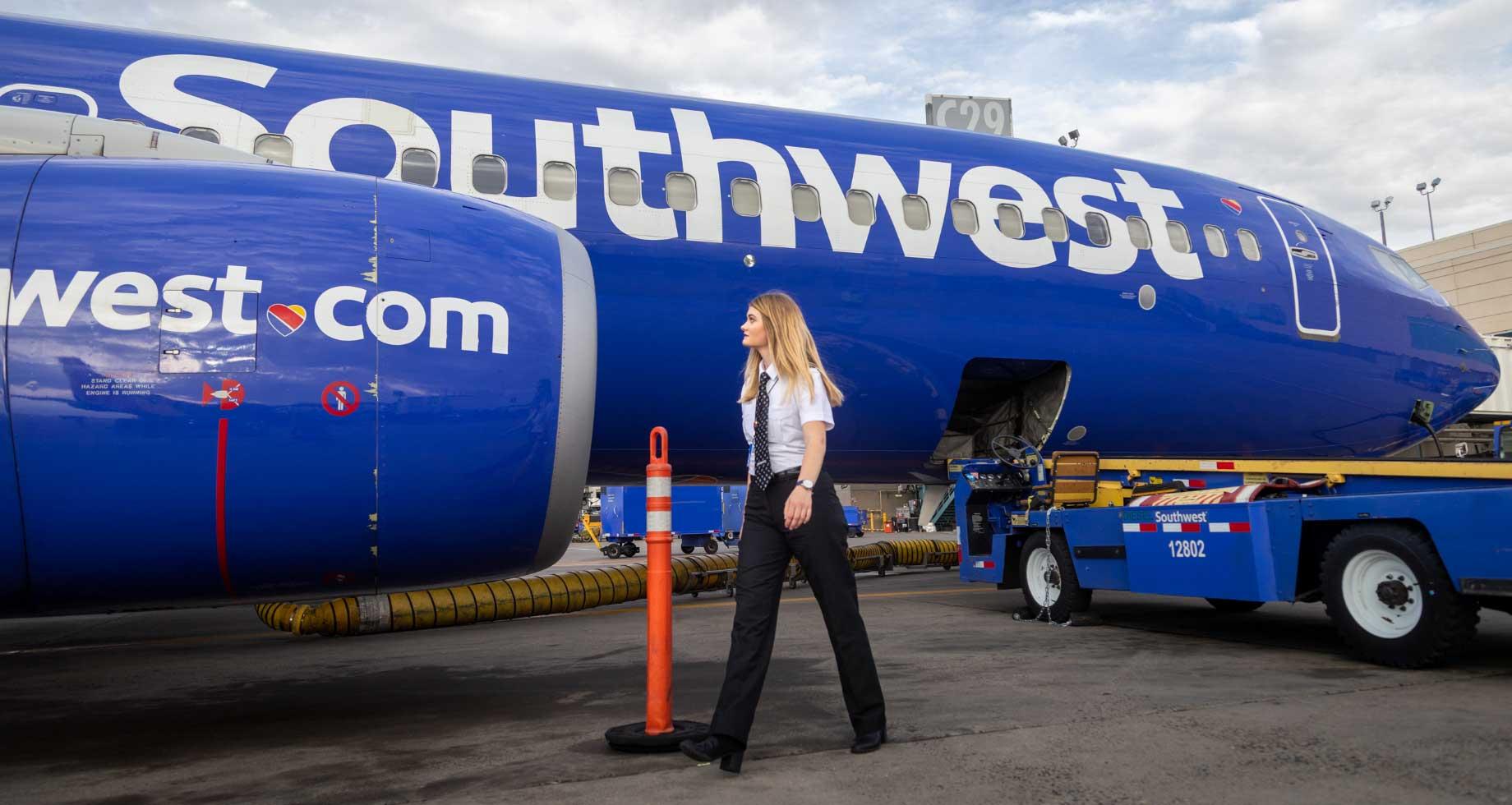 Southwest Company employee walking in front of a Southwest plane
