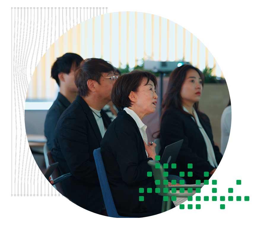 会議の場で笑顔で会話をしている 3 人の女性グループ。