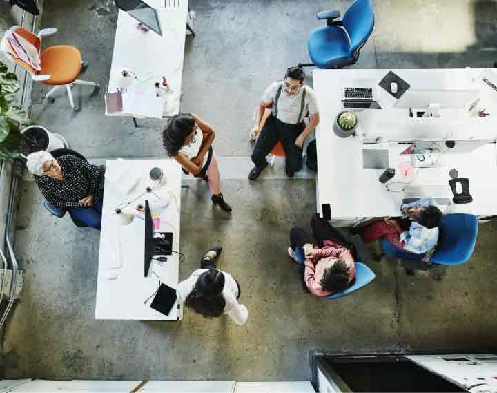 group of people sitting around tables at work