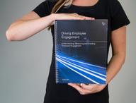 Click this thumbnail to show image: Person holding the Driving Employee Engagement Workbook.