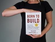 Person, die das Buch „Born to Build“ in der Hand hält.