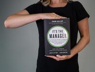 Klicken Sie auf diese Miniaturansicht, um das Bild anzuzeigen: Person, die das Buch „It's the Manager“ in der Hand hält.