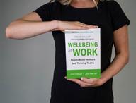 Person holding Wellbeing at Work.
